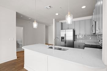 A modern kitchen with a white countertop and stainless steel appliances. at Mirabelle Luxury Apartments, Kansas City, MO